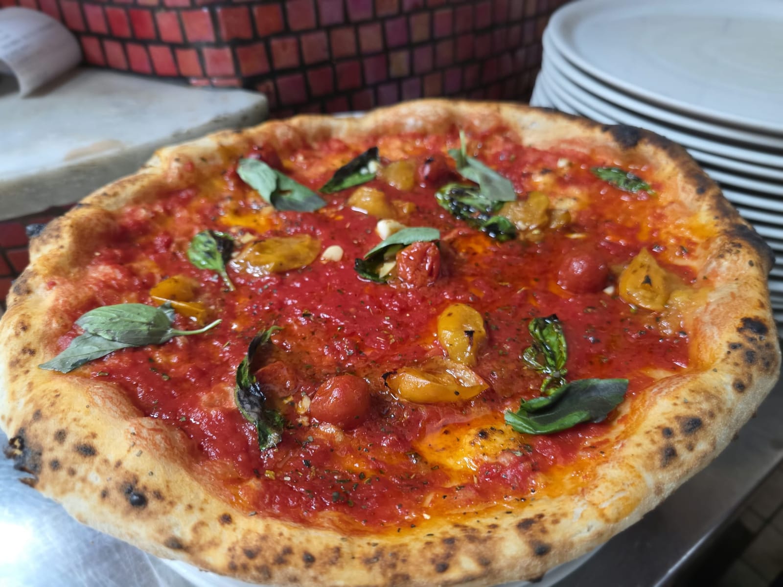Marinara vista dall’alto con pomodorini San Marzano e gialli del Piennolo, foglie di basilico e aglio, cornicione dorato